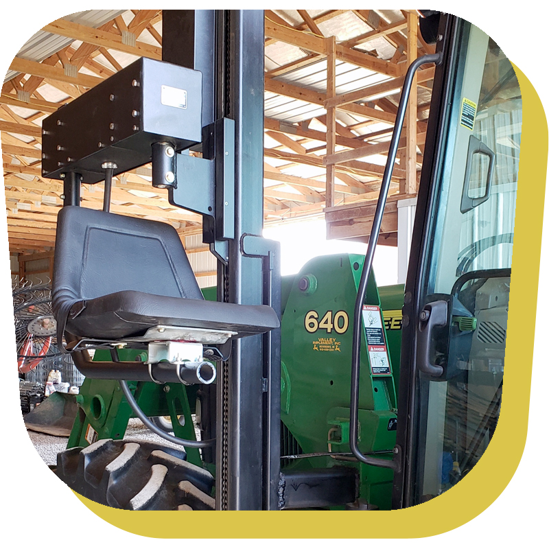 (A Lifelyfts Pilot Lift mounted to the side of a farm tractor.